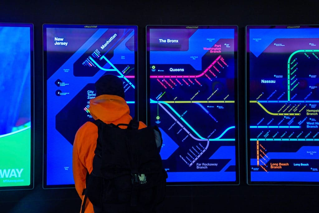 A commuter looks at the LIRR maps on digital displays in Grand Central Madison