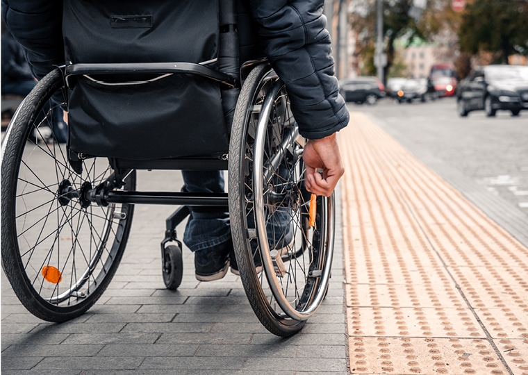 Man in a wheelchair approaches a curb