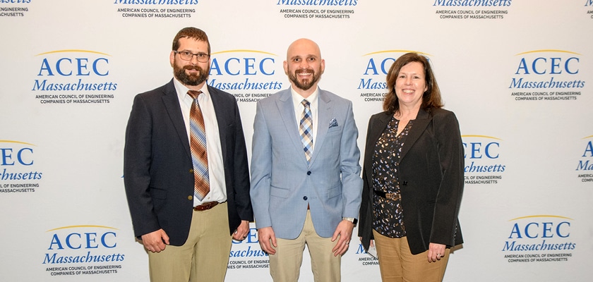 three people posing in front of ACEC step ad repeat banner